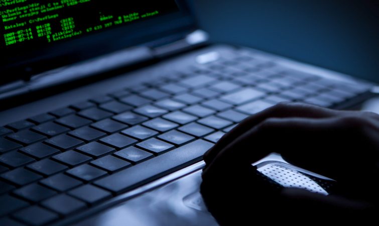 Hacker using laptop. Lots of digits on the computer screen.